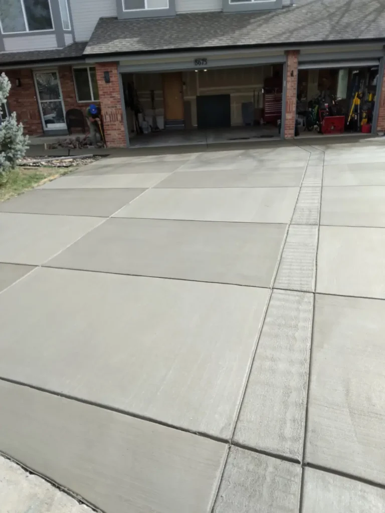 A well-designed concrete driveway by Northland Concrete Services, leading to a neatly maintained home.