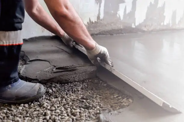 A worker smoothing a freshly poured concrete surface. Northland Concrete Services offers expert relaying and refinishing.