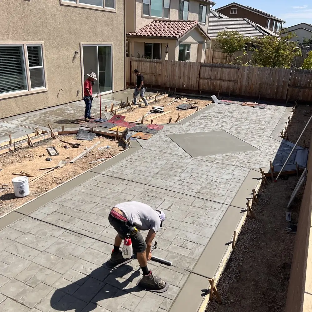 Northland Concrete Services ensuring the highest quality finish while applying texture and color to a stamped concrete driveway.