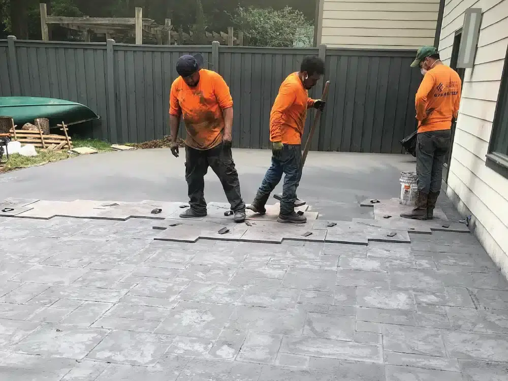 Northland Concrete Services team members expertly applying a stamped concrete design to enhance a residential concrete project.