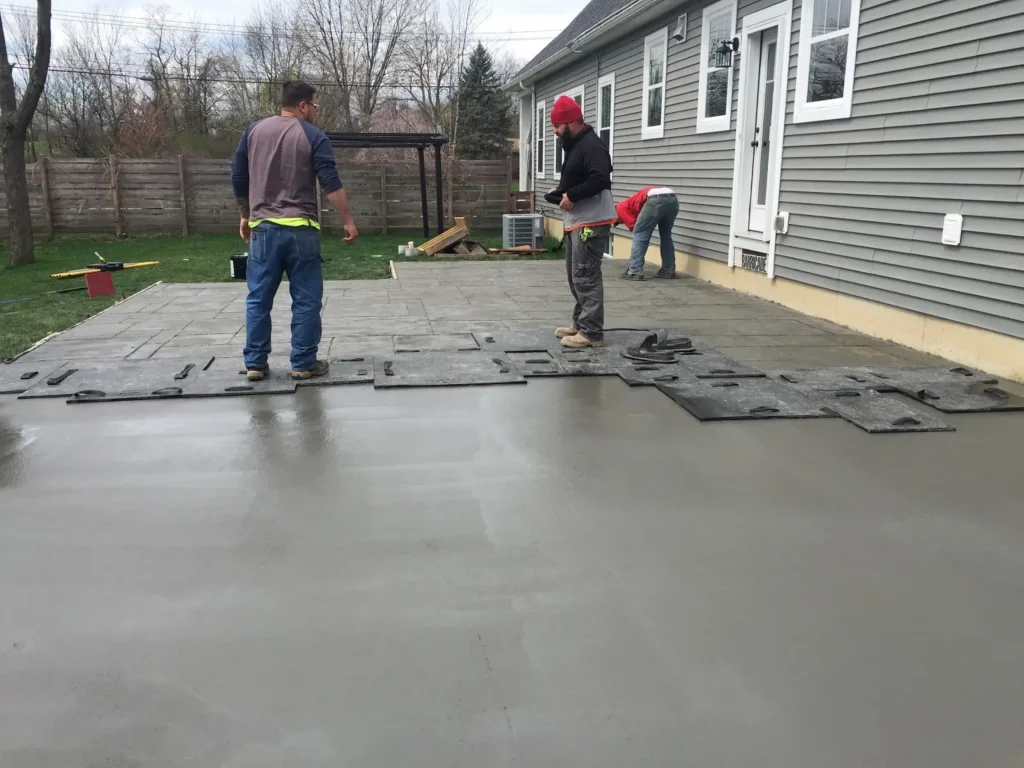The professionals at Northland Concrete Services applying stamping patterns to fresh concrete for a customized stamped concrete look.