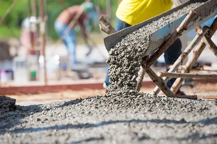 Wet concrete flowing from a chute for a strong foundation. Northland Concrete Services provides reliable foundation slabs.
