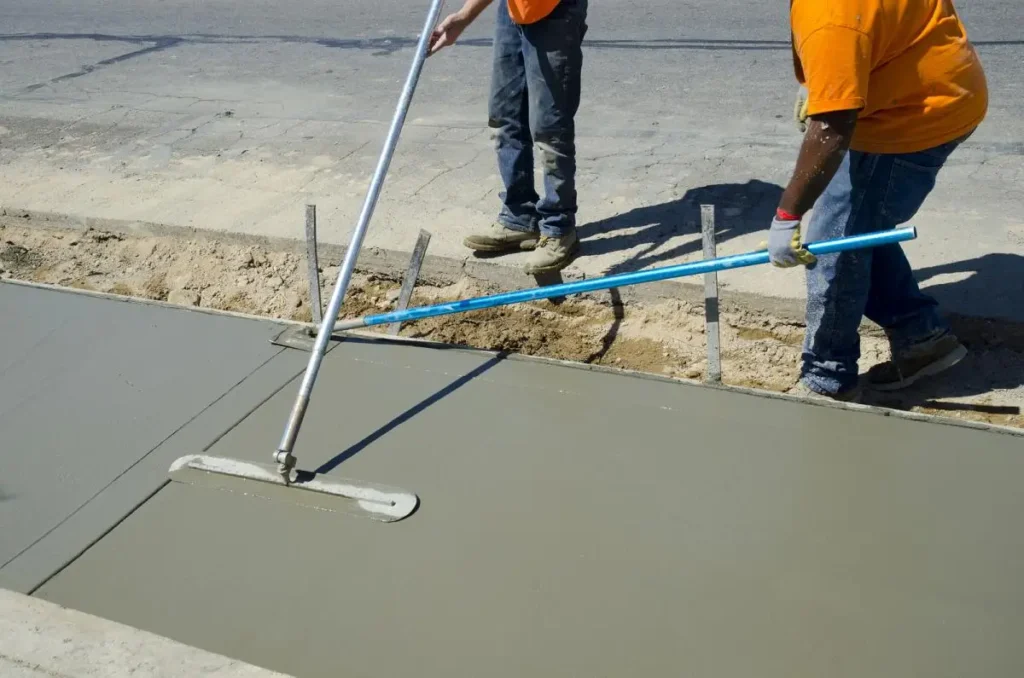 Workers smoothing a new sidewalk for an even finish. Northland Concrete Services offers professional sidewalk construction.